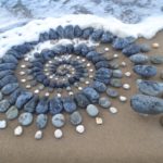 Artista surpreende as pessoas na praia deixando arranjos impressionantes de pedra ao longo da costa