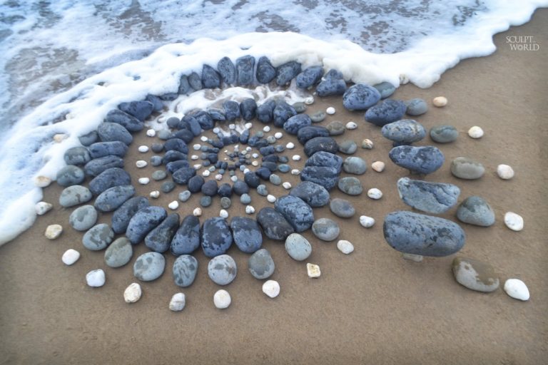 Artista surpreende as pessoas na praia deixando arranjos impressionantes de pedra ao longo da costa