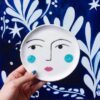 Figuras femininas, elementos cósmicos e paisagens naturais em tons de azul