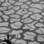 Artista caminha ao longo da costa para criar projetos simétricos antes da chegada da maré alta