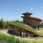 Casa espiral é construída com madeira, terra e telhado verde