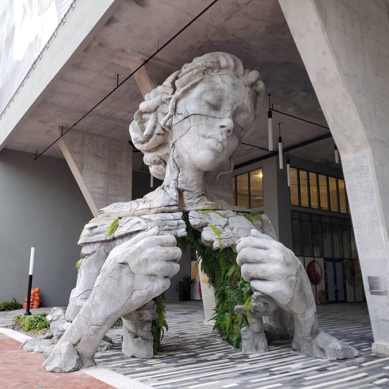 Uma figura monumental revela um túnel com cobertura de samambaia em escultura de Daniel Popper